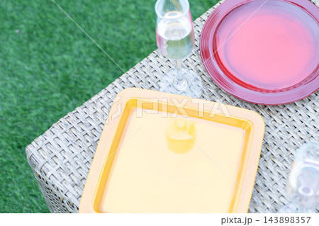 カラフルな食器のある屋外パーティーのテーブル。芝生のある庭。 カラフルな食器のある屋外パーティーのテーブル。芝生のある庭。 143898357