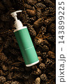 Green cosmetic dispenser bottle with white pump on natural pine cones and dry needles background  143899225