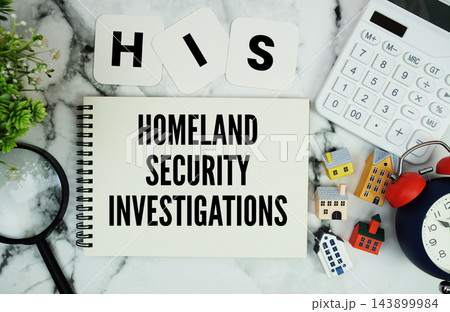 HIS Homeland Security Investigations text written on notepad with house model, calculator, magnifying glass and alarm clock on marble background 143899984