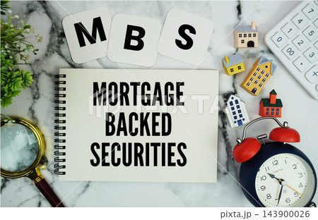 MBS Mortgage-Backed Securities text written on notepad with house model, calculator, magnifying glass and alarm clock on marble background MBS Mortgage-Backed Securities text written on notepad with house model, calculator, magnifying glass and alarm clock on marble background 143900026