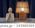 Abstract sculpture and wooden lamp illuminate a minimalist interior table 143900369