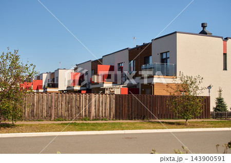 Modern Townhouses with Red Balcony Accents and Wooden Fence Modern Townhouses with Red Balcony Accents and Wooden Fence 143900591