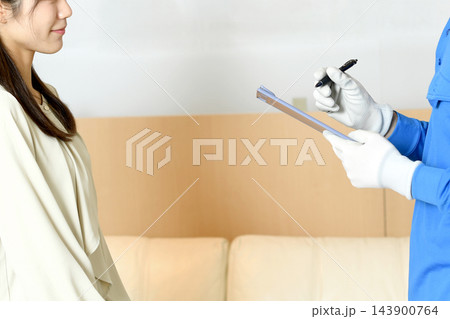 出張買取の見積もりを説明する作業員と女性 出張買取の見積もりを説明する作業員と女性 143900764