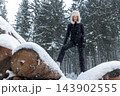 Portrait young adult mid age smile woman enjoy have fun walking in park forest snowfall cold winter day. Female portrait person happiness wear black ski overall stylish fur hat snowflakes background 143902555