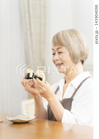 リビングで一人おにぎりを食べる リビングで一人おにぎりを食べる 143904098