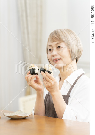 リビングで一人おにぎりを食べる リビングで一人おにぎりを食べる 143904099