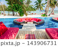Luxury pool lounge beside tropical beach with vibrant resort seating 143906731