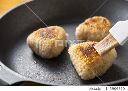 焼おにぎりに刷毛で醤油を塗る 焼おにぎりに刷毛で醤油を塗る 143906860