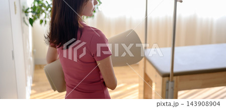 ヨガマットを抱えて歩く女性 143908904