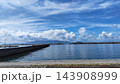 青空と夏の雲が広がる穏やかな港と海の景観 143908999