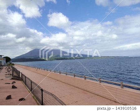 錦江湾越しに望む桜島と海沿いの整備された遊歩道 錦江湾越しに望む桜島と海沿いの整備された遊歩道 143910516