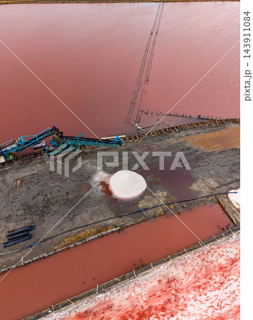 Salt extraction site with processing equipment and salt deposits in outdoor evaporation ponds Salt extraction site with processing equipment and salt deposits in outdoor evaporation ponds 143911084