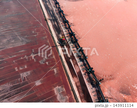 Salt extraction works with a conveyor system running beside a brine pond at an industrial site Salt extraction works with a conveyor system running beside a brine pond at an industrial site 143911114
