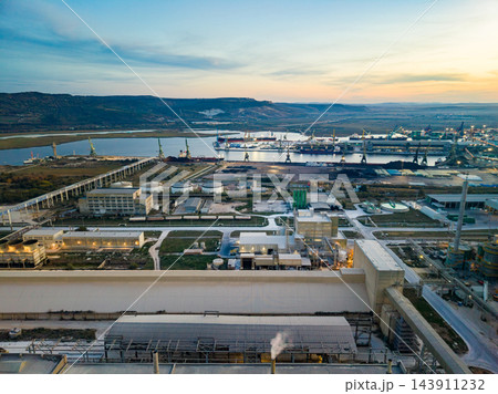 Industrial facility and port waterways seen from above at dusk on the coast Industrial facility and port waterways seen from above at dusk on the coast 143911232