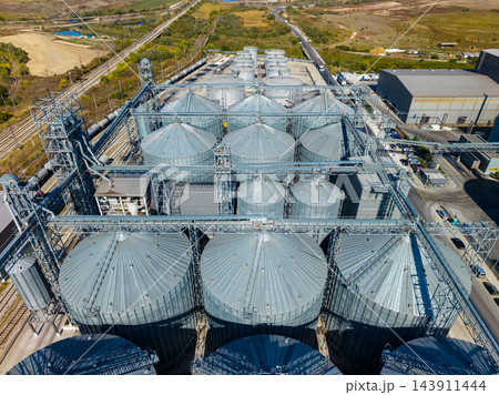 Aerial view of grain silos and conveyor systems at an agricultural storage facility during daylight 143911444