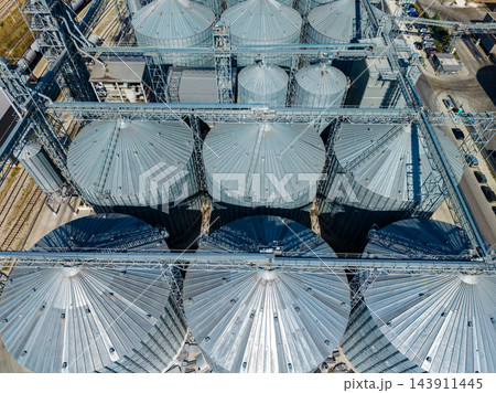 Aerial view of grain silos and conveyor structures at an agricultural storage facility during daylight 143911445