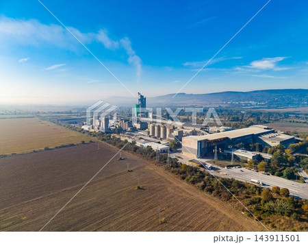 Aerial view of a cement plant and industrial complex beside fields under a clear sky during daylight 143911501