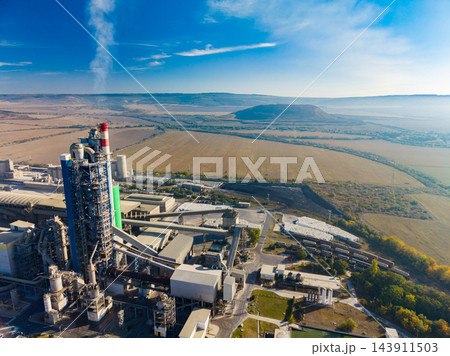 Industrial cement plant and conveyor system in a rural landscape under a clear sky 143911503