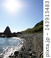 きらめく水面と石垣沿いの海岸線、岩峰を望む構図 143913483