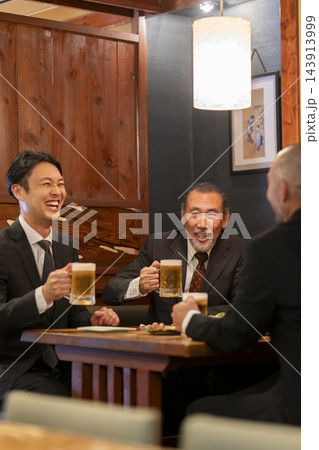 居酒屋で談笑するビジネスマングループ 143913999