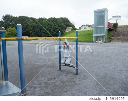 夏の公園の遊具で楽しく遊んでいる十代の女の子の姿	 143914995