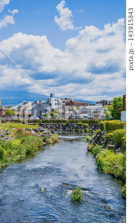 静岡県富士宮市を流れる神田川の清流と雲広がる縦位置の街並み風景 143915843