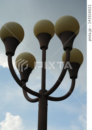 Unique Street Lamp Design Against Cloudy Sky 143916021