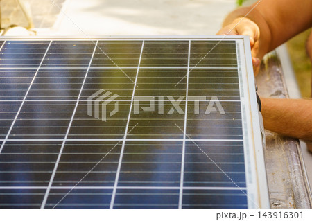 Working on solar panel installation on a roof of caravan in bright sunlight with tools nearby Working on solar panel installation on a roof of caravan in bright sunlight with tools nearby 143916301