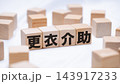 更衣介助のテキストが書かれた木のブロック 143917233