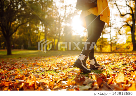 Women's feet walk on autumn leaves in the forest. Rest, relaxation, lifestyle concept. Women's feet walk on autumn leaves in the forest. Rest, relaxation, lifestyle concept. 143918680