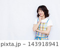 腕組みをして笑顔で考えている主婦 143918941