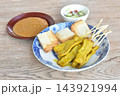 grilled pork satay stabing wooden stick couple bread dipping with sweet peanut sauce and pickled vegetable Indonesian food on plate 143921994