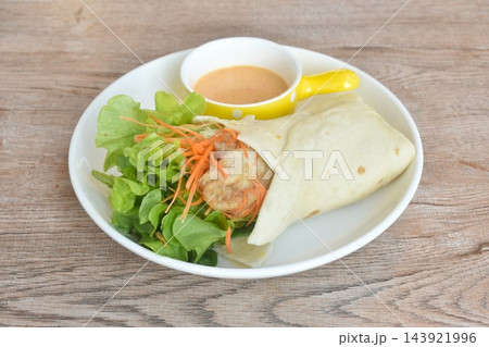 roti flour wrap grilled chicken with fresh vegetable salad dressing spicy mayonnaise cream sauce on plate roti flour wrap grilled chicken with fresh vegetable salad dressing spicy mayonnaise cream sauce on plate 143921996