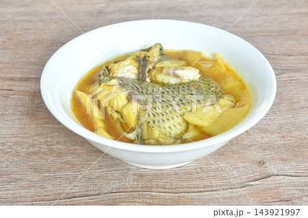 boiled red mango fish with pickled bamboo shoot in spicy and sour yellow curry soup Thai southern food on bowl boiled red mango fish with pickled bamboo shoot in spicy and sour yellow curry soup Thai southern food on bowl 143921997