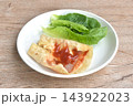 berrito stuffed slice ham pork with cheese dressing ketchup sauce eat couple fresh cos lettuce vegetable salac on plate 143922023