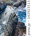 Ocean waves flow through a rocky coastal inlet as seawater breaks against the shore 143923513