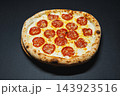 Pepperoni pizza with melted cheese served on a dark surface after baking 143923516