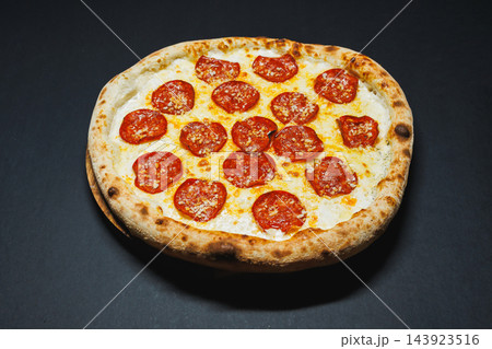 Pepperoni pizza with melted cheese served on a dark surface after baking 143923516