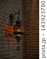 Antique Oriental Metal Lantern Glowing with Warm Amber Light on Brick Wall. Uzbekistan. 143923780