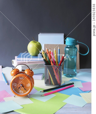 A workspace with school supplies and an alarm clock for studying. School supplies and study materials on a desk. "Back to school" concept.  143923838