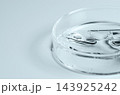 Testing a transparent cosmetic product in a Petri dish. Copy space 143925242
