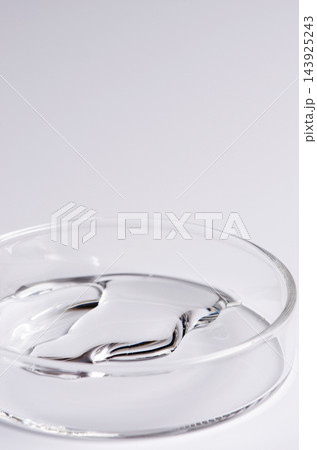 Testing a transparent cosmetic product in a Petri dish. Copy space 143925243