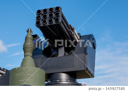 Modern military rocket launcher mounted against clear blue sky 143927580
