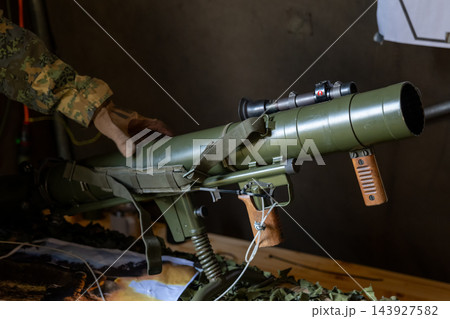 Camouflaged Soldier Handling a Green Anti-Tank Rocket Launcher Camouflaged Soldier Handling a Green Anti-Tank Rocket Launcher 143927582