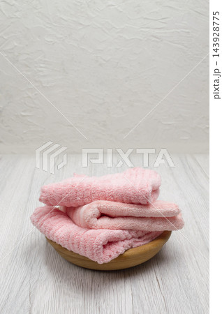 Pink folded towels on a light background, offering a clean mockup for design with room for text and branding. Pink folded towels on a light background, offering a clean mockup for design with room for text and branding. 143928775