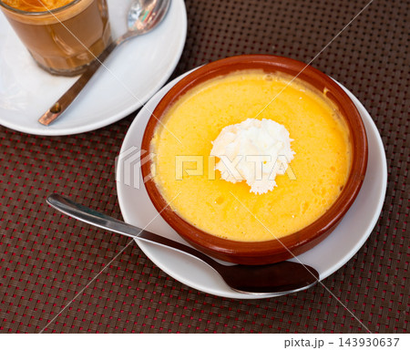 Velvety mango mousse topped wit whipped cream in clay bowl 143930637