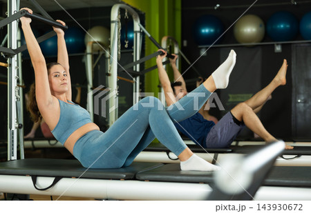 Young woman doing teaser exercise on pilates reformer Young woman doing teaser exercise on pilates reformer 143930672