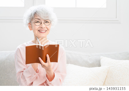 スケジュール帳を見るシニア女性 スケジュール帳を見るシニア女性 143931155