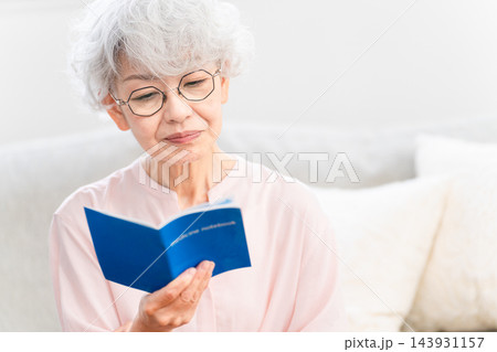 おくすり手帳を確認するシニア女性 143931157