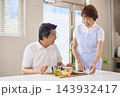 介護施設で食事を提供されるシニア男性とスタッフのシニアの女性 143932417